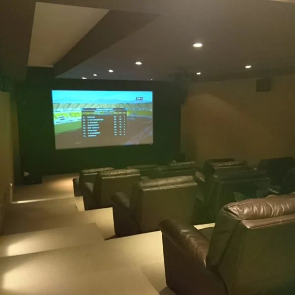 Cine en casa con sillones reclinables y una pantalla grande, creando un ambiente cómodo y acogedor para disfrutar películas.